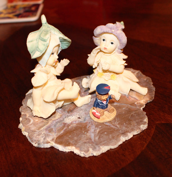 Vintage Garden Fairies Playing with a Bear Toy Sitting on a Slab