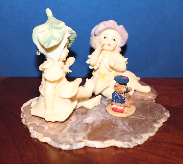 Vintage Garden Fairies Playing with a Bear Toy Sitting on a Slab